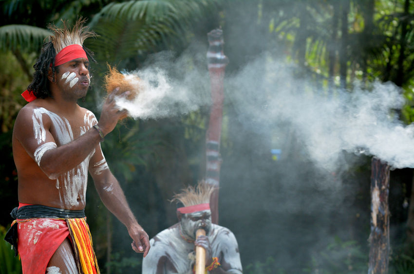 45816576 - yugambeh aboriginal warrior demonstrate  fire making craft during aboriginal culture show in queensland, australia.
