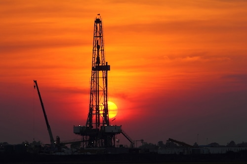 Sunset at oil drilling rig in the field